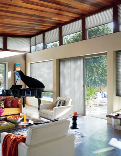 Modern living room with black grand piano and honeycomb track blind system