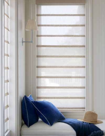 Translucent white roman pull shades with blue pillows